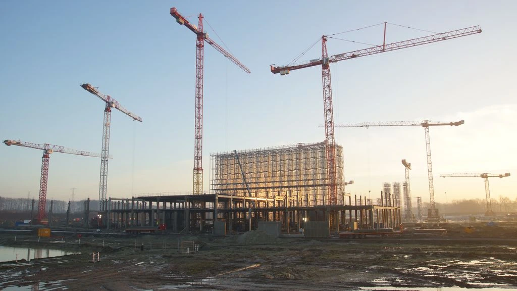 Estructura metálica de una nave logística en ejecución al atardecer en el País Vasco.
