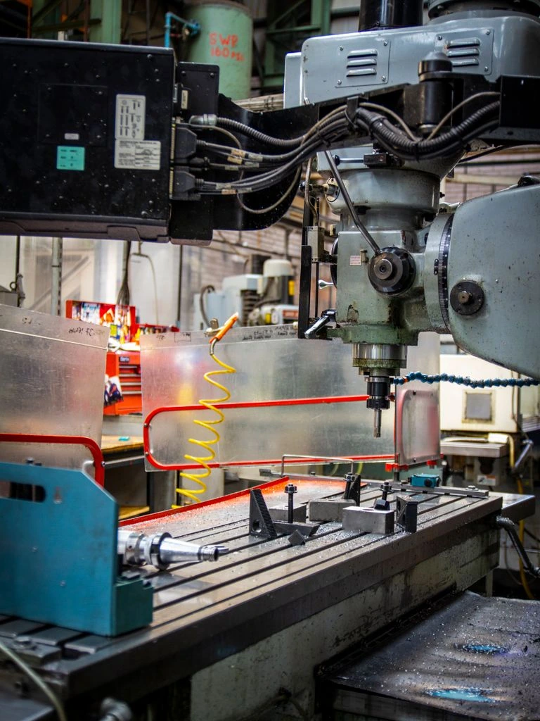 Interior de planta de mecanizado de precisión con puente grúa y nueva entreplanta de hormigón.